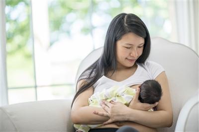 Young mother breastfeeding newborn