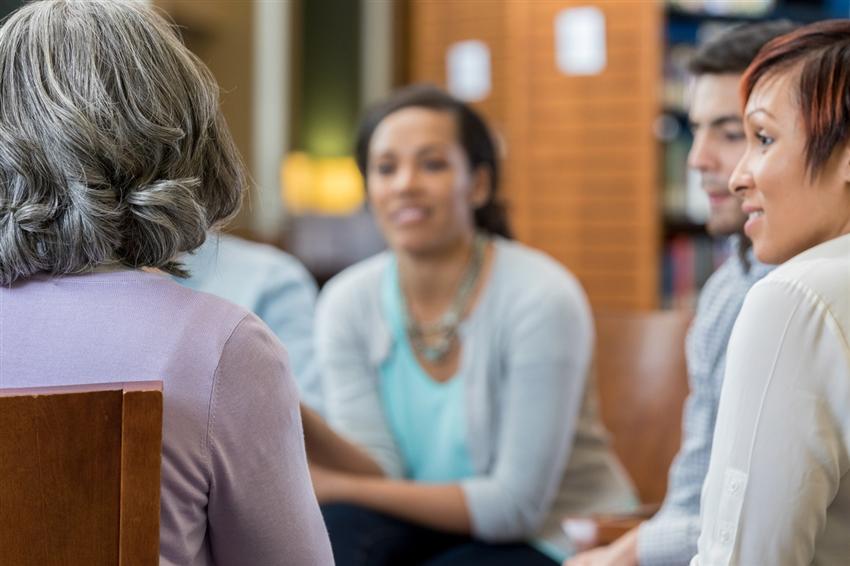 Unrecognizable woman shares story in group therapy